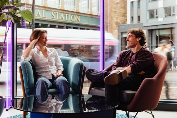 Couple sitting on chairs in window